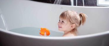 Klein meisje neemt een bad met badspeeltje